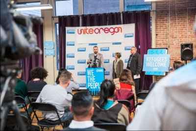 Press conference at Unite Oregon A crowd observes a press conference at Unite Oregon
