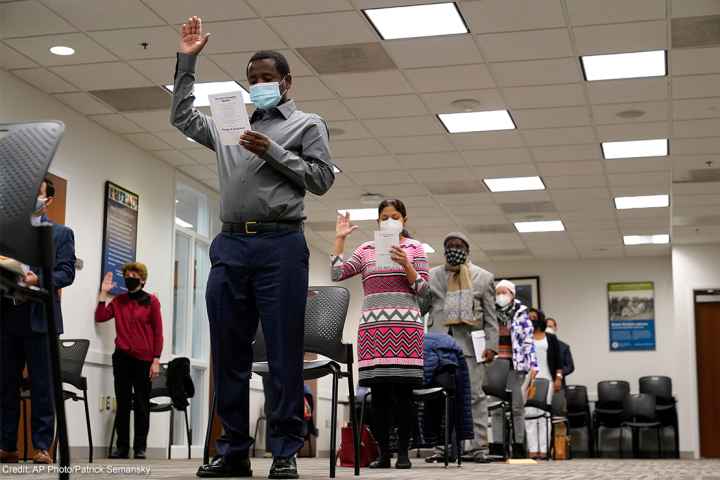 Candidates for American citizenship recite the Oath of Allegiance during a naturalization ceremony.