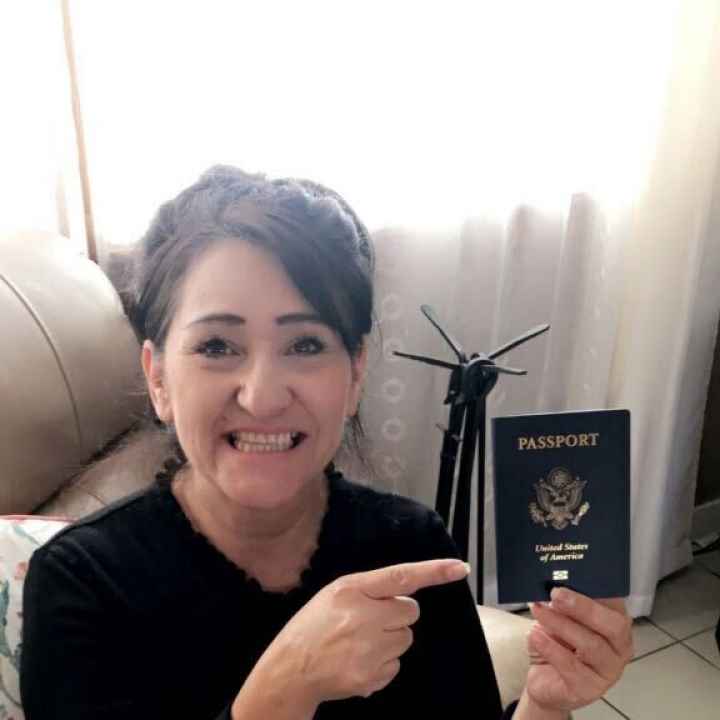 Maria Soto holds her passport and points to it